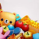 Kuvassa on animoituja leluja ja ruokia, kuten nallekarhuja, pizzaa, mansikoita, perunalastuja, ankka ja muita värikkäitä esineitä valkoisella taustalla