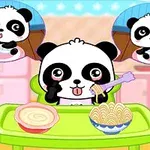 Panda syö pastaa ja keittoa vihreän pöydän ääressä, ja taustalla on kaksi ilmapalloa, jotka esittävät pandaa eri tilanteissa