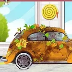 Kuvassa on vanha auto, joka on peitetty syksyn lehdillä ja mudalla