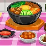 Erilaisia japanilaisia ruokia aseteltuna pöydälle, mukaan lukien kulhossa oleva ateria, teekuppi ja kimchi