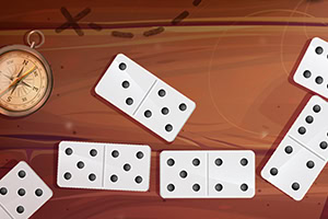 Kompassi ja domino-palikoita puupintaisella taustalla