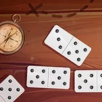 Kompassi ja domino-palikoita puupintaisella taustalla