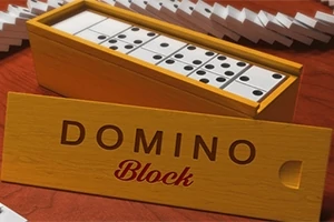Kuvassa on avoin puinen dominolaatikko, jossa näkyy useita dominokappaleita sekä edessä kannessa lukee DOMINO Block