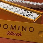Kuvassa on avoin puinen dominolaatikko, jossa näkyy useita dominokappaleita sekä edessä kannessa lukee DOMINO Block