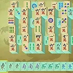 Mahjong-palikoita järjestettynä perinteiselle pelilaudalle kultaisella taustalla, etualalla erillinen rivi palikoita