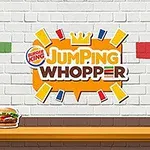 Valkoisella tiiliseinällä on värikkäitä tiililaattoja, keskellä Jumping Whopper -logo ja pöydällä hampurilainen