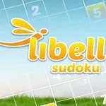 Sudokuruudukko, jossa on keltainen libelle sudoku -teksti ja kuvio, taustalla sininen taivas ja vihreää ruohoa