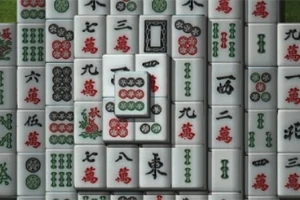 Valkoisia mahjong-laattoja, joissa on punaisia, vihreitä ja mustia merkkejä, järjestettynä päällekkäin ja vierekkäin