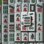 Valkoisia mahjong-laattoja, joissa on punaisia, vihreitä ja mustia merkkejä, järjestettynä päällekkäin ja vierekkäin