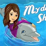 Nuori nainen ratsastaa delfiinillä vedessä värikkään pallon vieressä, taustalla teksti My Dolphin Show