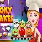 Kuvassa on hahmo kokinhatussa, värikkäitä halloween-kupinpäällysteitä ja teksti Spooky Cupcakes