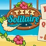 Puinen kyltti, jossa lukee Tiki Solitaire, meren rannalla, kukkien koristamana, ja kolme pelikorttia henkilöhahmoilla