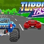 Sininen monsteriauto ja punainen urheiluauto ajavat vierekkäin maantiellä, taustalla vihreitä puita ja Turbo Tastic -teksti