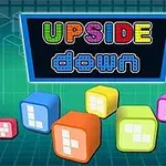 Värikkäitä kuutioita eri kokoisina ja kirjaimet muodostavat sanat UPSIDE down sinisellä taustalla
