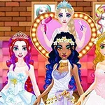 Kolme pukeutunutta prinsessaa, joilla on kruunut, seisoo yhdessä kampaamohuoneessa, taustalla näkyy kampaaja sydämen muotoisessa kehyksessä