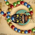Mustapantteri avaa suunsa, ympärillä värikkäitä palloja ja taustalla egyptiläisiä hieroglyfejä